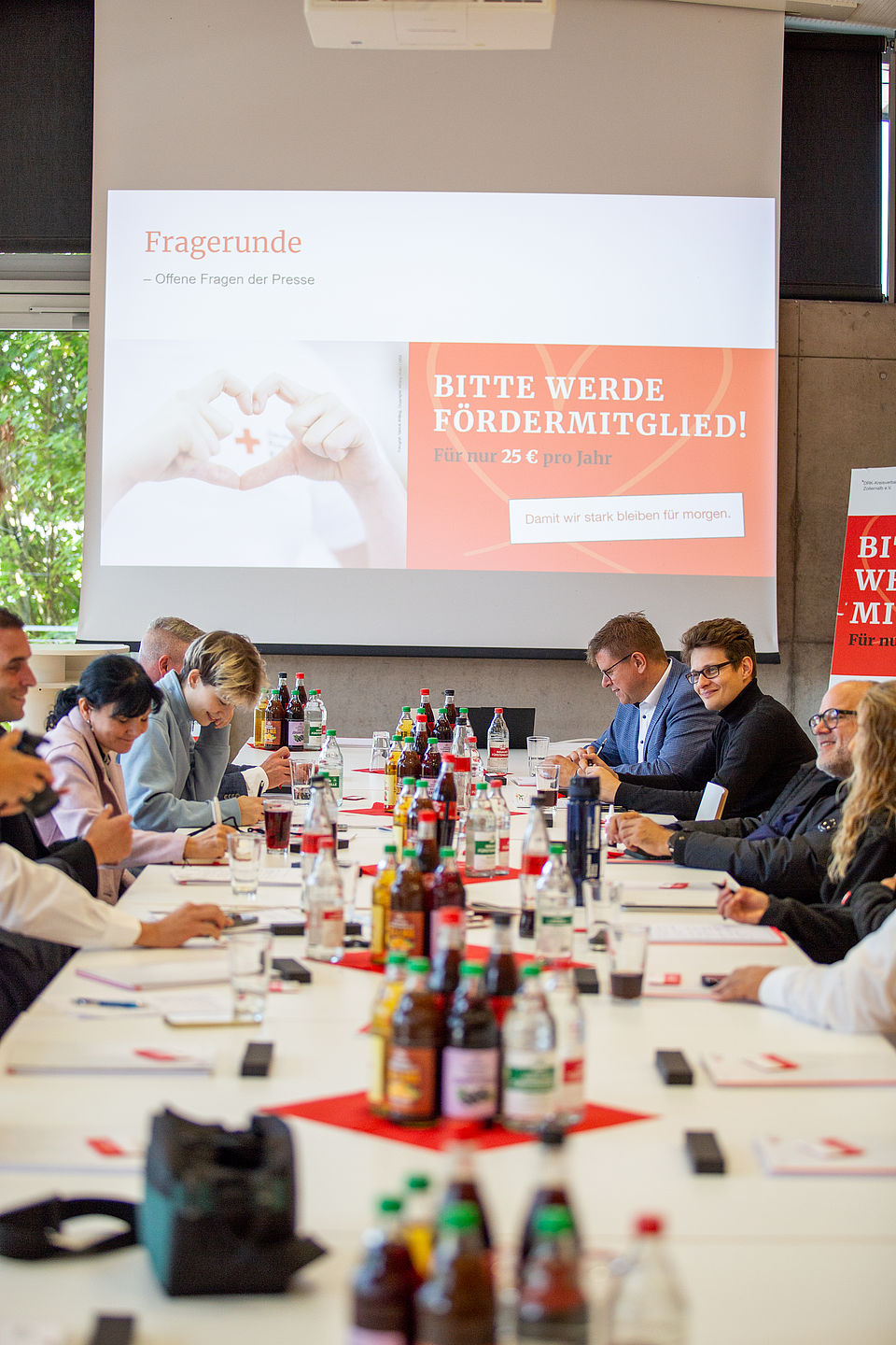 Teilnehmer der Pressekonferenz sitzen am Tisch