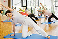 Damen bei der Gymnastik am Boden mit Übungsmatte